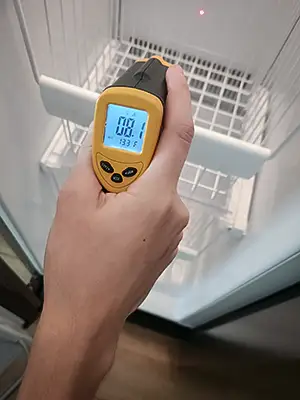 Checking the temperature inside a freezer to ensure it's in good condition.